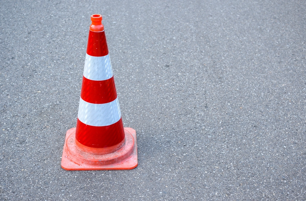 Orange and white traffic cone on asphalt